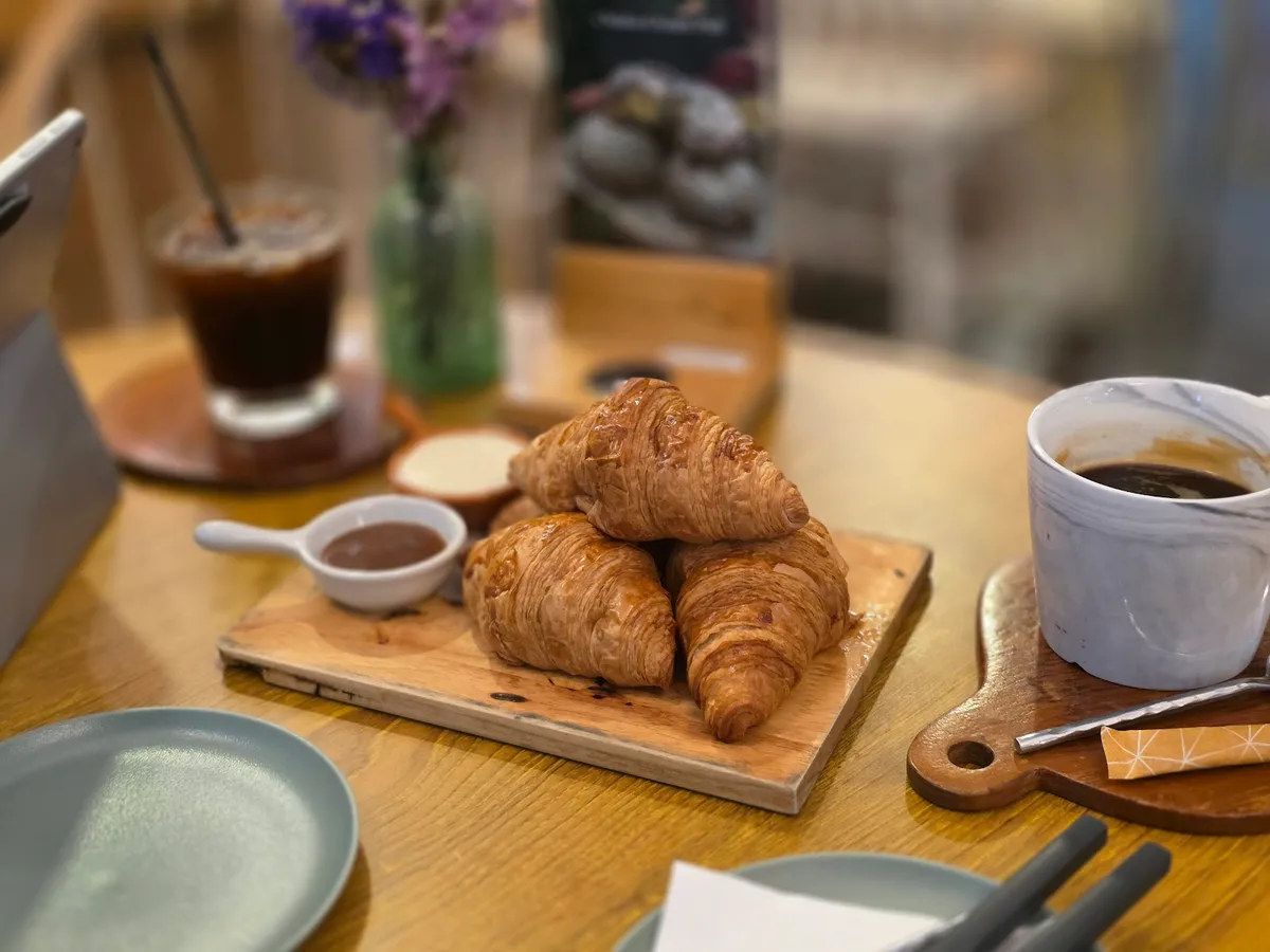 Fresh croissants on a board with coffee