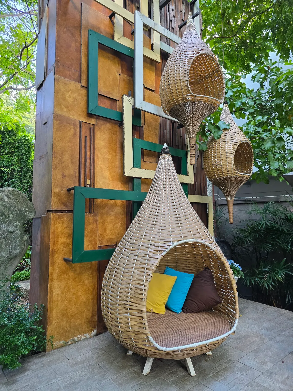 Hanging rattan nest seats in a decorated garden corner