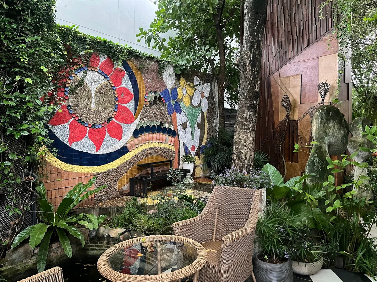 A mosaic art wall and koi pond in the garden