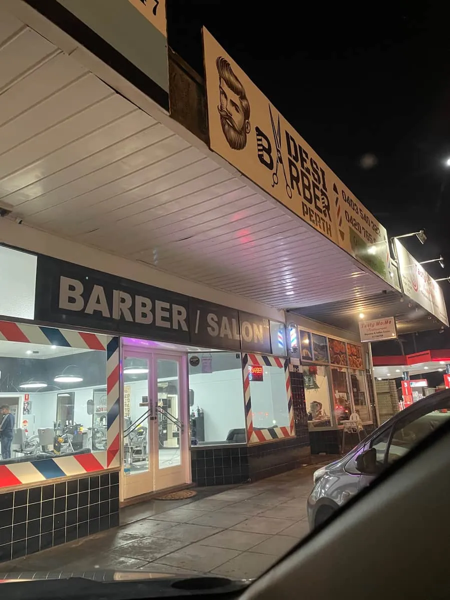 The Desi Barber sign at night