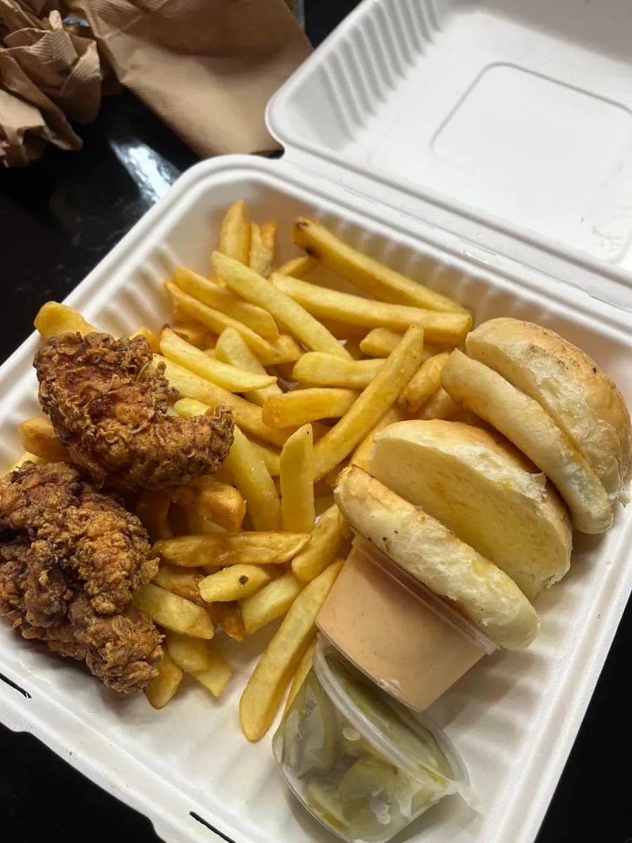 Crispy chicken tenders with chips, slider buns and a tub of house sauce