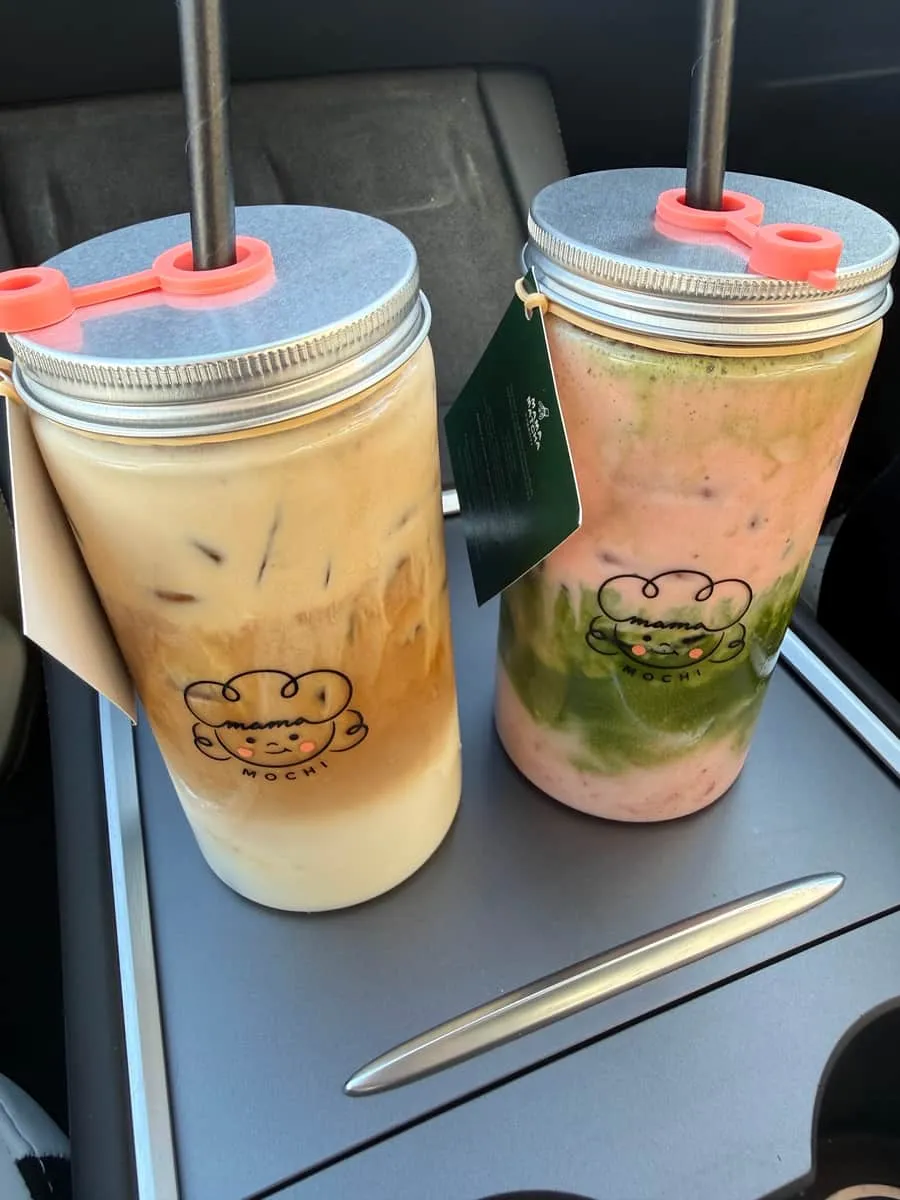 A banoffee coffee in a mason jar — caramel and coffee layered over milk, beside a strawberry matcha