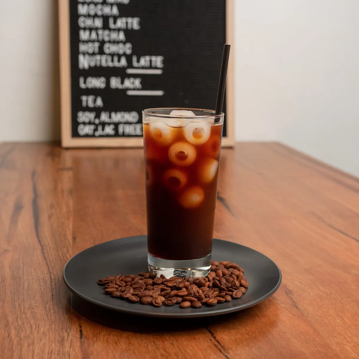 Iced long black over a plate of coffee beans