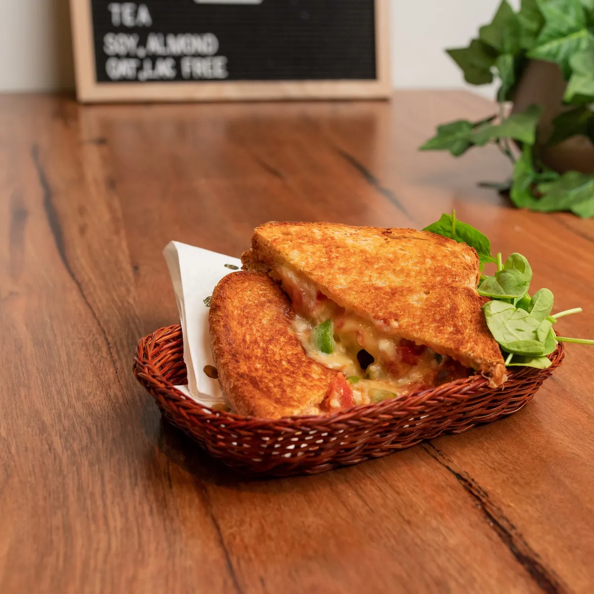 Toasted sandwich in a basket with spinach